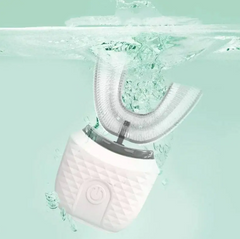 White dental cleaning device with water droplets on a light green background