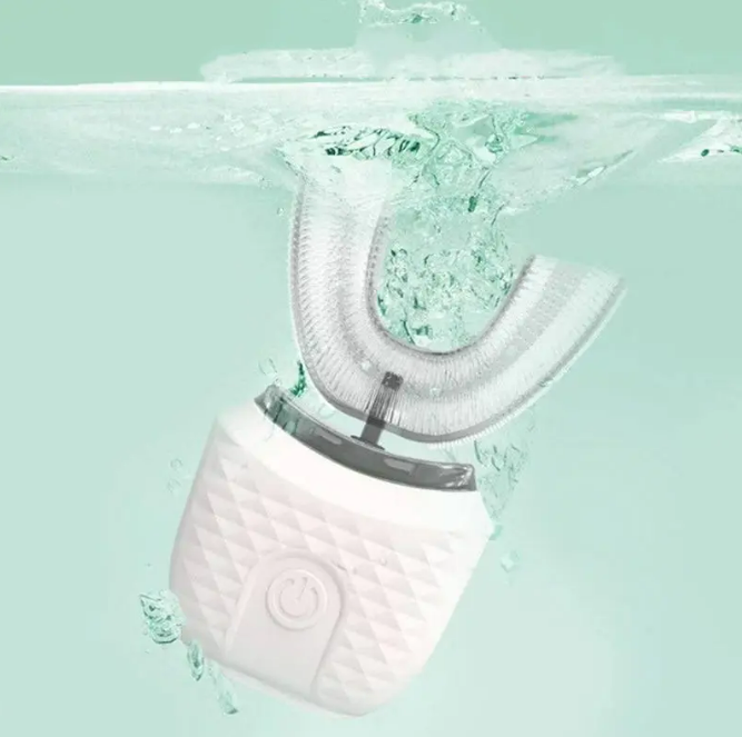 White dental cleaning device with water droplets on a light green background